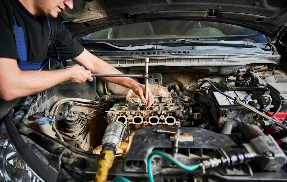 Mechanik pracuje nad naprawą silników w samochodzie.